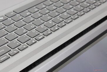 Grilles between the keyboard and hinge are for airflow and not for audio