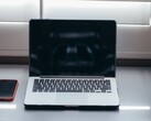 Open laptop and smartphone side by side on a desk in daylight