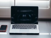 Open laptop and smartphone side by side on a desk in daylight