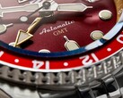 Macro shot of the Seiko 5 Sports GMT HDB016’s burgundy sunray dial, showing its gold-tone GMT hand, luminous hour markers, and rotating bezel