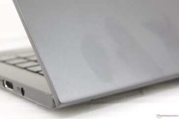 Outer lid is slightly roughened matte aluminum. Fingerprints are more difficult to see on the dark gray color
