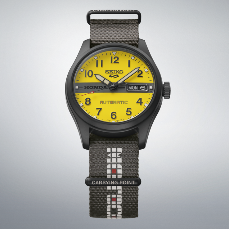 Front view of the Seiko 5 Sports Field x Honda Motocompo Limited Edition with a yellow dial, black Honda logo across the center, and gray nylon strap.