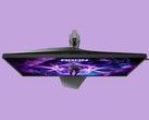 The image shows the AOC AG276UZ gaming monitor against a purple background. The gaming monitor features a very gamery design, complete with RGB on its rear.