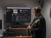 Guitar player plays in front of a monitor showing the app StemKit