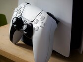 A picture of a PlayStation 5 DualSense controller leaning against a PS5 console