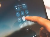 A finger entering a PIN on a keypad on screen