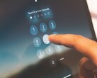 A finger entering a PIN on a keypad on screen
