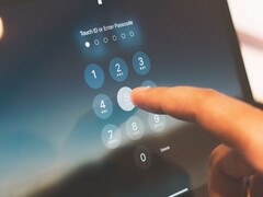 A finger entering a PIN on a keypad on screen