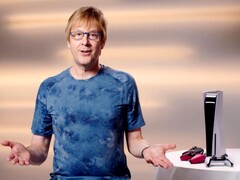  Mark Cerny during a PlayStation event, seated beside a PS5 console and DualSense controllers. (Image Source: Sony Interactive Entertainment)