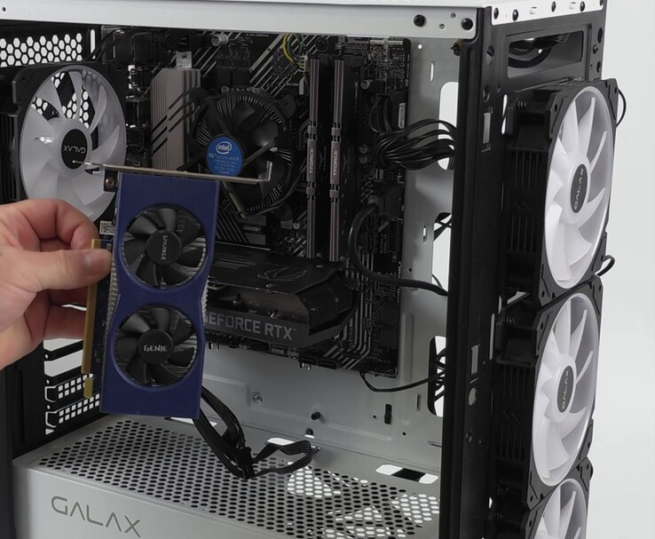 A hand holding an Intel Arc A380 graphics card next to a PC build featuring an Nvidia GeForce RTX 3060, prepared for a dual-GPU setup with Lossless Scaling (Image source: ETA Prime via YouTube)