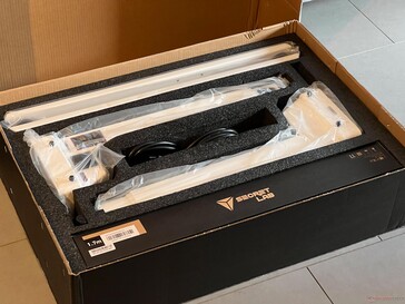 The smaller package contains leg columns, table feet & the desk mat.