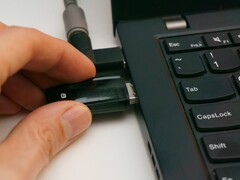 A person inserts a USB security key into a laptop