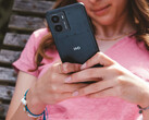 A promotional image for HMD's Fusion smartphone showcasing the phone in a woman's hands with a close-up on the HMD logo on the back. (Image Source: HMD)