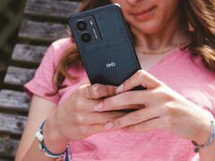 A promotional image for HMD's Fusion smartphone showcasing the phone in a woman's hands with a close-up on the HMD logo on the back. (Image Source: HMD)