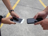 Two people holding two smartphones side by side at a handover