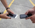 Two people holding two smartphones side by side at a handover