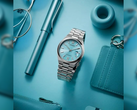 Pictured - the Citizen Tsuyosa NJ0151-88M against a blue background with other items.