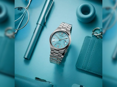 Pictured - the Citizen Tsuyosa NJ0151-88M against a blue background with other items.