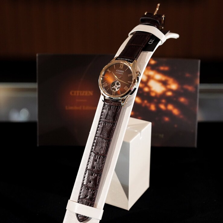 The Citizen watch mounted on a white, curved display stand. The image showcases the full length of the crocodile-embossed dark brown leather strap and the reflective brown dial,