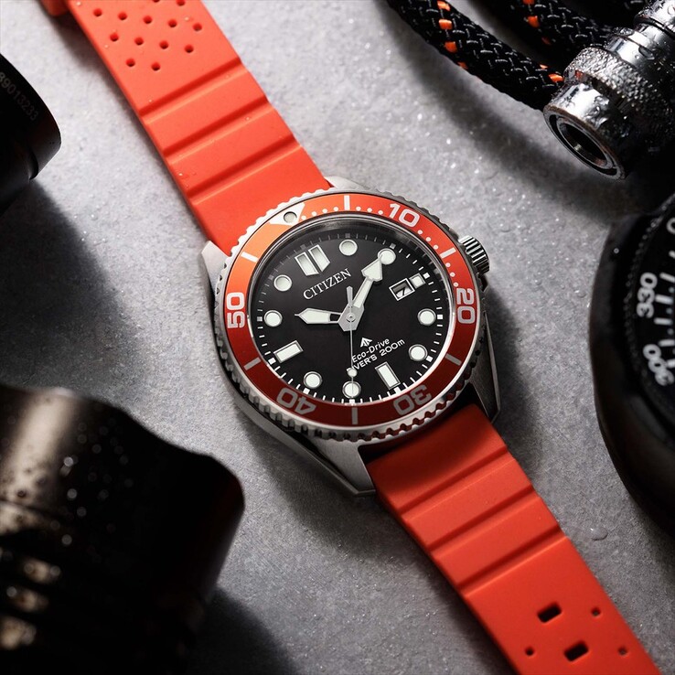 Citizen Promaster Marine BN0268-01E dive watch with a black dial, orange bezel, and orange strap photographed on a textured surface.