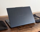 The image shows a photo of the Yoga Slim 7X laptop from behind.