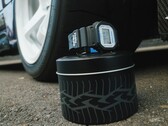 Casio G-Shock DW5600TT25-1 x Toyo Tires watch displayed on a tire-themed metal tin next to a car wheel.