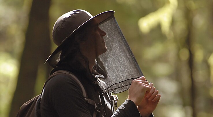 A hiker wearing a protective head net to shield against midges and other biting insects during outdoor activities (Image source: LifeSystems)