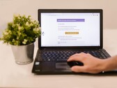 Laptop on a table showing a phishing email with a confirmation button