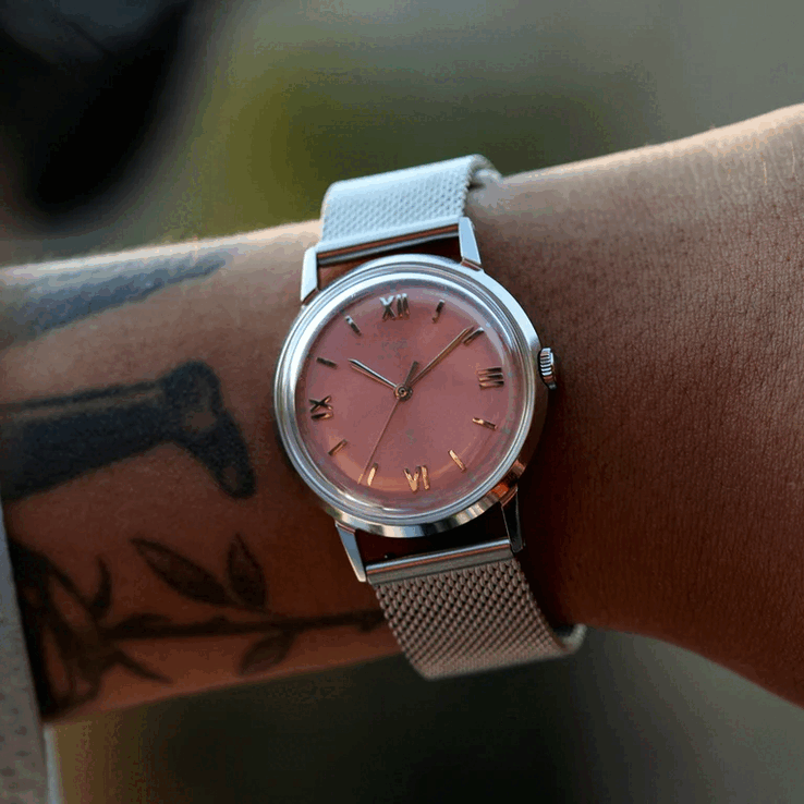 Person wearing the Timex x Todd Snyder Marlin Mesh with a salmon sunburst dial and mesh bracelet.