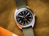 The Timex x Bespoke Post limited-edition 36mm watch, pictured with an olive Cordura strap against a dark mustard background. (Image source: Timex)