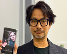 Hideo Kojima showing a poster of Physint on his phone