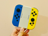 Stock image. A hand holding Joy-Cons (Image source: Gwen King on Unsplash)