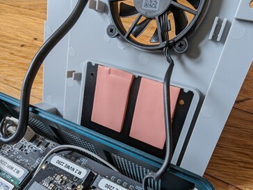 Each SSD slot has its own thermal pad attached to a larger heat sink on the fan bracket
