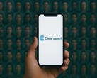 Smartphone with Clearview AI on it, face database in the background (Image source: AI-generated)