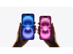 A promotional image for the iPhone 16 that show two pairs of hands holding two different color variants on a grey background. (Image Source: Apple)