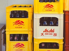 Stacked yellow and white plastic crates filled with Asahi beer bottles, featuring Japanese text and red logos. (Image source: Photo by Alazne Lazcano via Pexels)