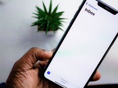 Hand holding an iPhone with an open email inbox