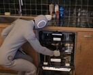 The humanoid home robot 1X Neo is loading a dishwasher (Image source: WSJ on YouTube/screenshot).