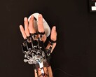 A DIY exoskeleton device strapped to a hand while using a gaming mouse (Image source: Basically Homeless/YouTube)