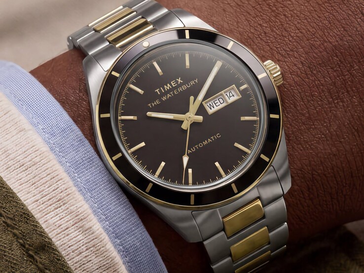Two-tone Timex Waterbury Heritage Automatic with black dial worn on a wrist, showing its day-date display and gold-tone accents.