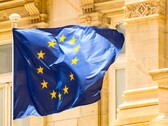 EU flag flying in front of historic architecture