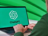 A man is typing on a laptop with the ChatGPT logo visible on the screen