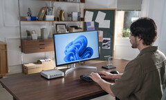 Minisforum has refreshed its AI X1 Pro mini-PC, pictured next to a monitor and keyboard on a desk, with new AMD hardware (image source: Minisforum)