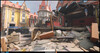 This Overwatch 2 scene shows a war-torn urban corner, where collapsed masonry and shattered facades cut through the map’s otherwise clean, stylized architecture.