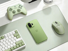 The OnePlus 15T is said to sport a 360° surround high-performance antenna setup. Pictured: the phone placed beside a mouse, controller, and keyboard.