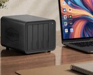 The image shows the Terramaster D8 Hybrid 2 NAS next to a laptop on a wooden desk