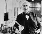 Thomas Edison with the light bulb he invented in 1883 (Unknown photographer, Public domain, via Wikimedia Commons)