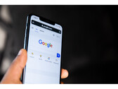 A photo of a hand holding a smartphone with the Google Search homepage open on screen. (Image Source: Solen Feyissa on Flickr)