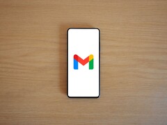 Smartphone showing the Gmail logo on a wooden table