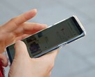 A hand holds an Android smartphone showing a map app.